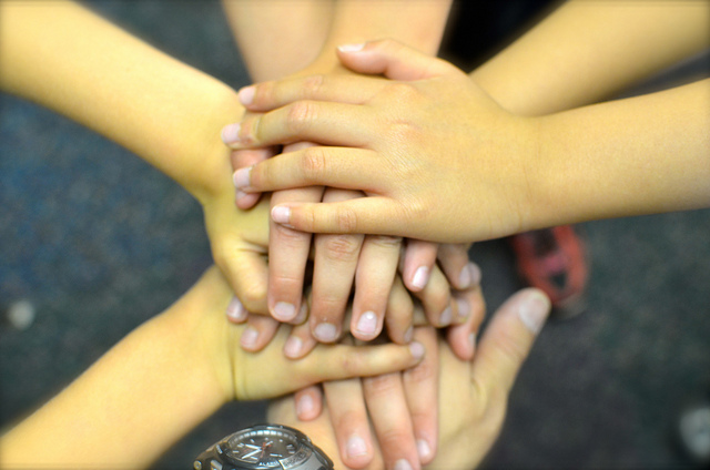 Many hands stacked together in the middle